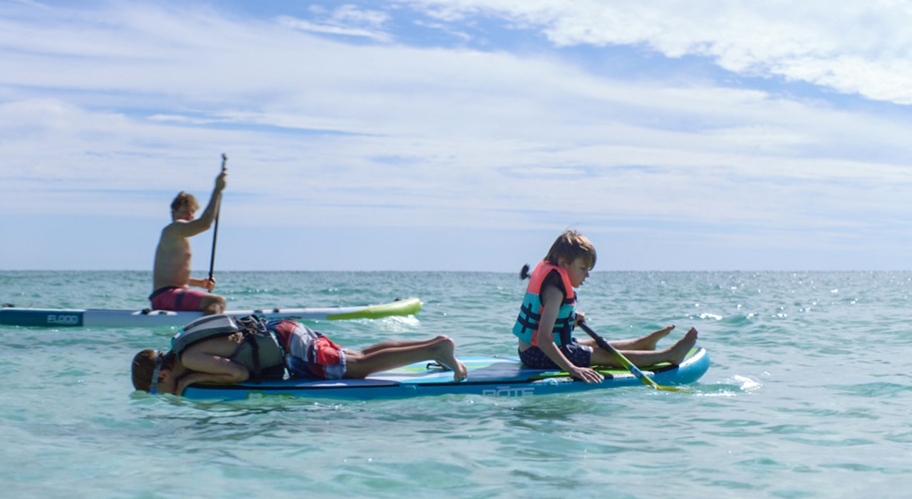 family paddleboarding in the destin florida waters near legendary